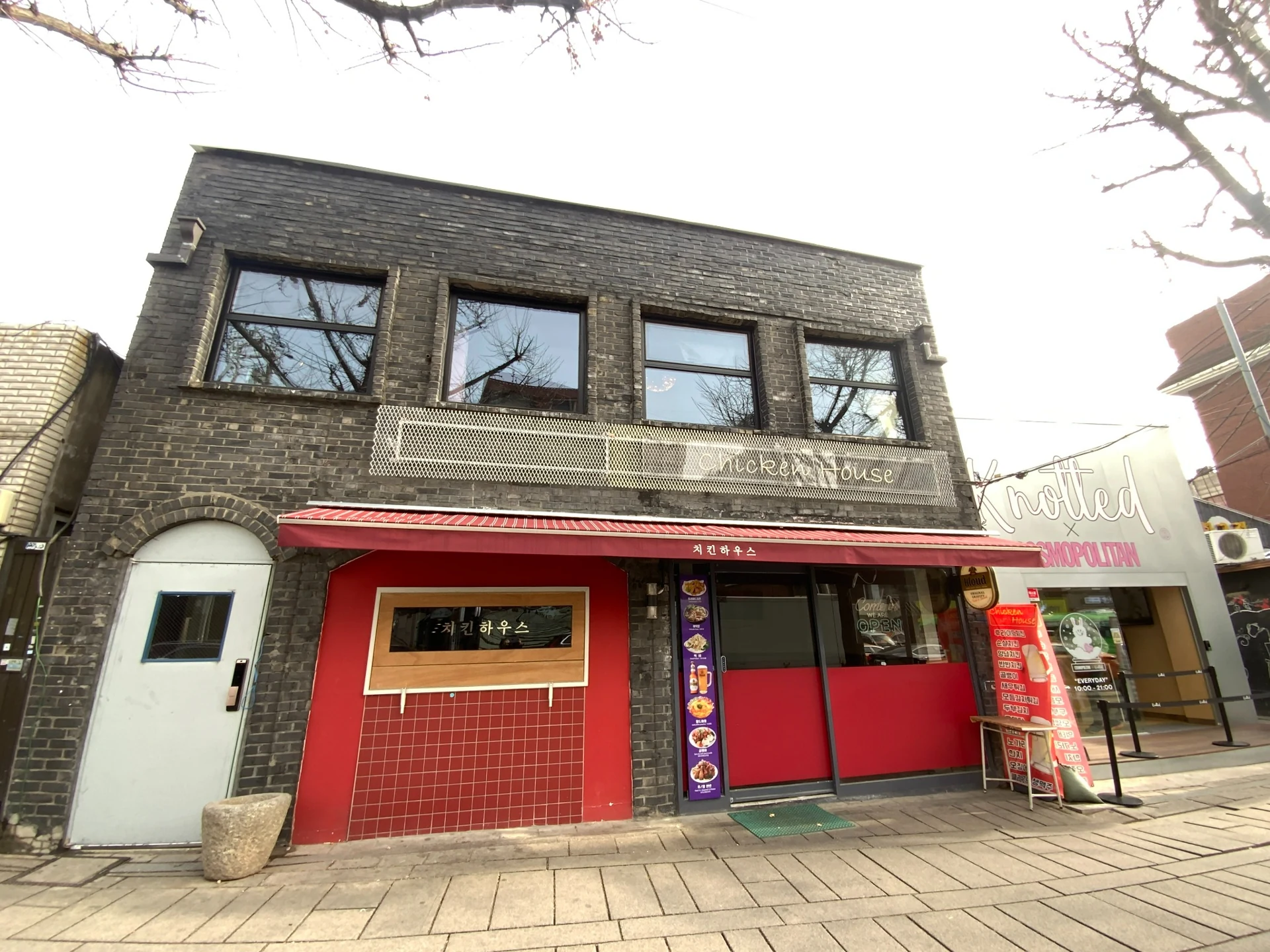 김정선 디렉터가 디자인하고 신색애 팀이 공사한 안국역 꼬마빌딩 외관: 짙은 벽돌과 붉은 매장 입구